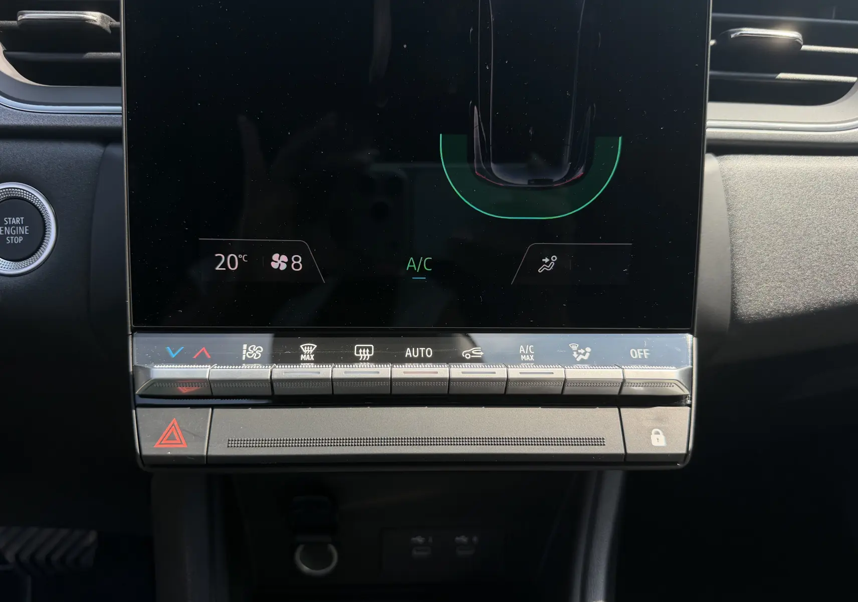 Gros plan sur la console centrale tactile du Renault Captur gris Cassiopée, affichant les commandes climatisation et démarrage.