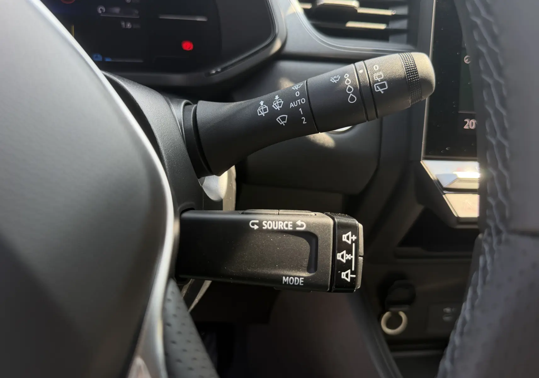 Gros plan sur les commandes au volant du Renault Captur 1.8 E-Tech gris Cassiopée, avec leviers de clignotants et multimédia.
