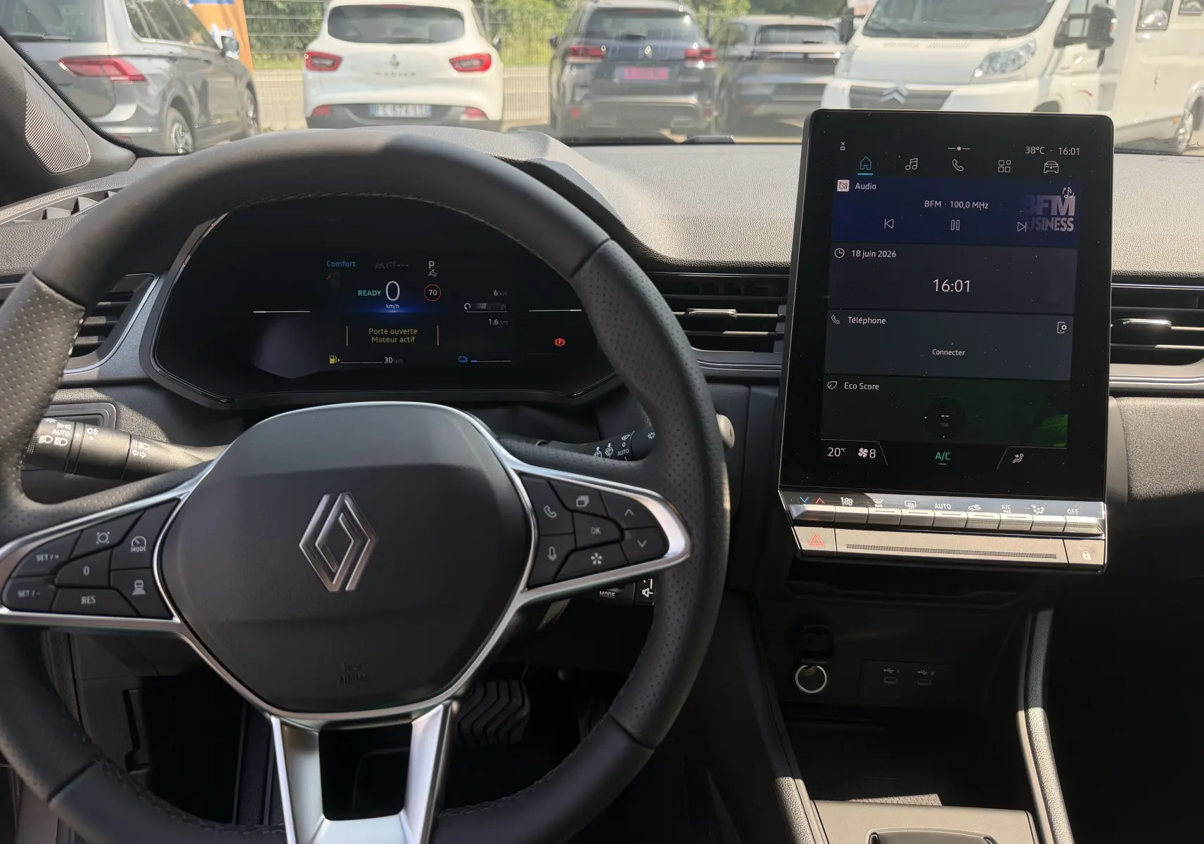 Vue intérieure avant du tableau de bord et volant Renault Captur 2026, avec écran tactile vertical et commandes au volant.