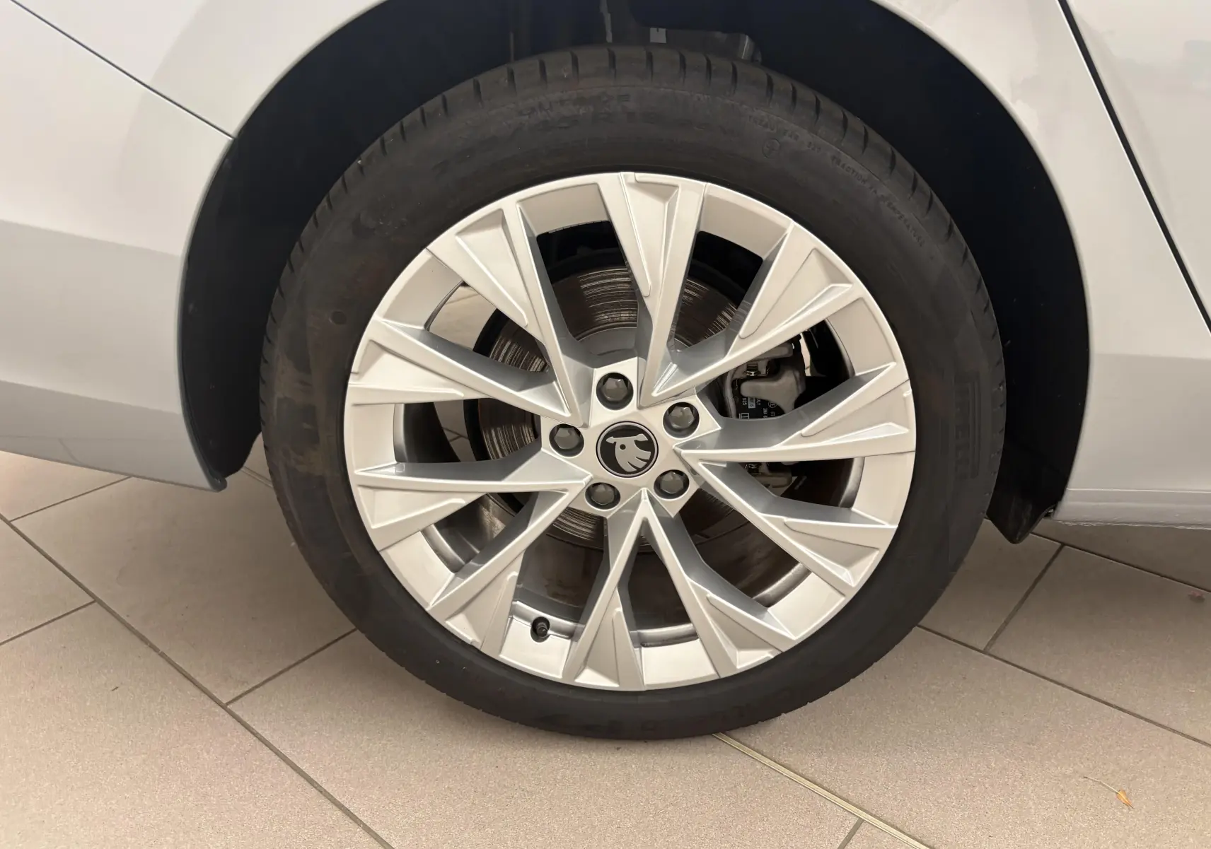 Gros plan sur la jante alliage argent 18 pouces du côté arrière droit d’une Skoda Superb Combi gris argent.