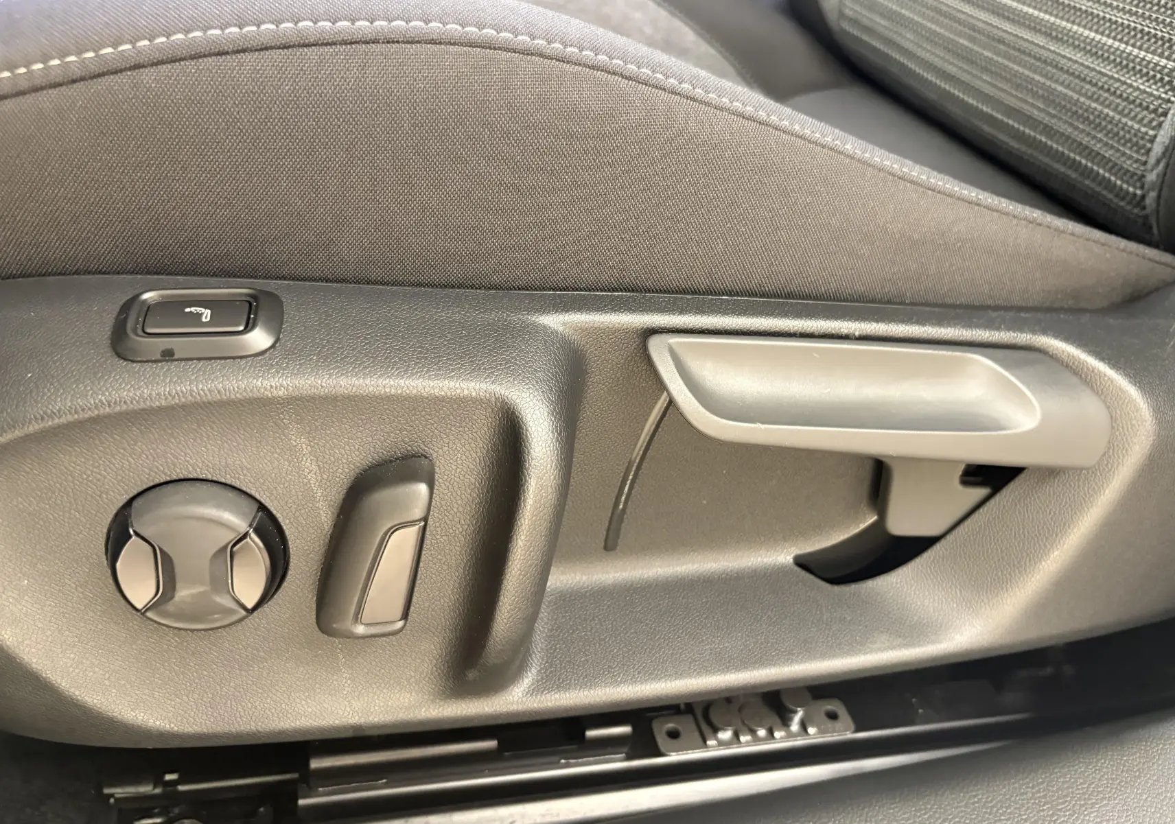 Détail des commandes de réglage manuel du siège avant dans une Skoda Superb Combi gris argent 2025.