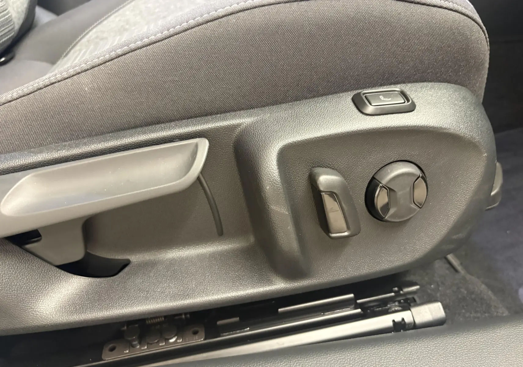 Détail des commandes de réglage manuel du siège avant côté conducteur dans une Skoda Superb Combi gris argent 2025.