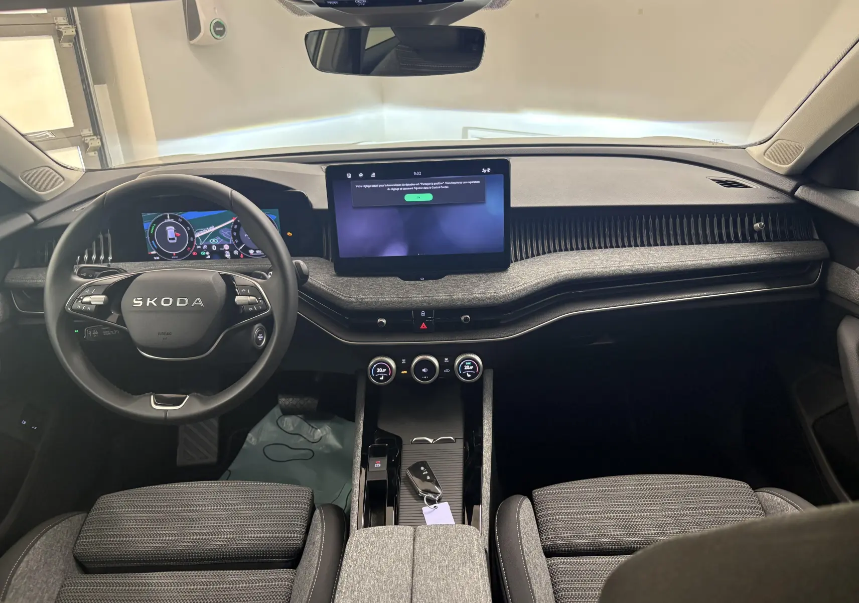 Vue intérieure avant de la Skoda Superb Combi 2025, tableau de bord moderne avec écran tactile central et volant multifonctions.