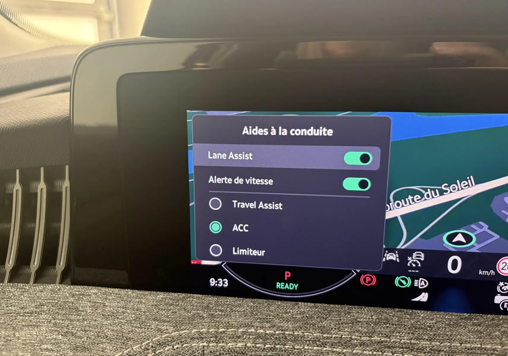 Écran tactile intérieur affichant les aides à la conduite activées sur Skoda Superb Combi gris argent.