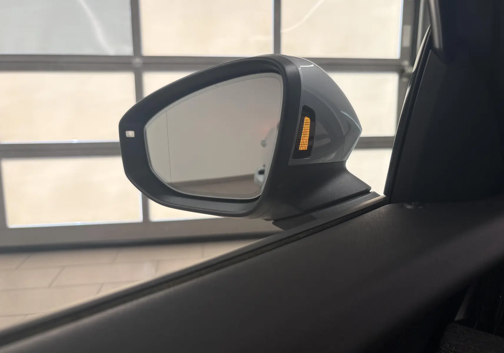 Rétroviseur côté gauche de la Skoda Superb Combi gris argent avec clignotant latéral allumé, vue intérieure.