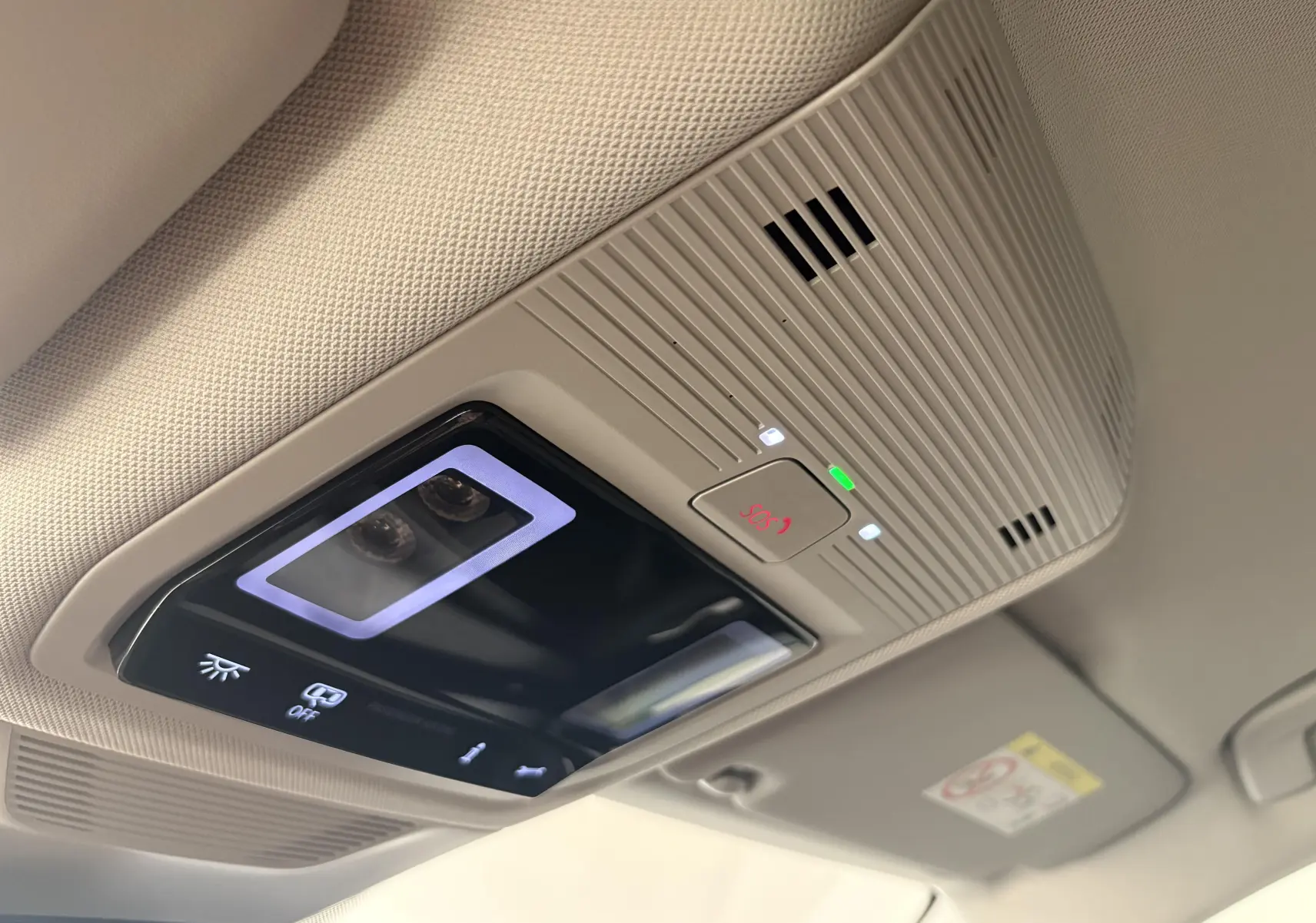 Plafonnier intérieur avec commandes lumineuses et bouton SOS du Skoda Superb Combi gris argent, vue en légère contre-plongée.