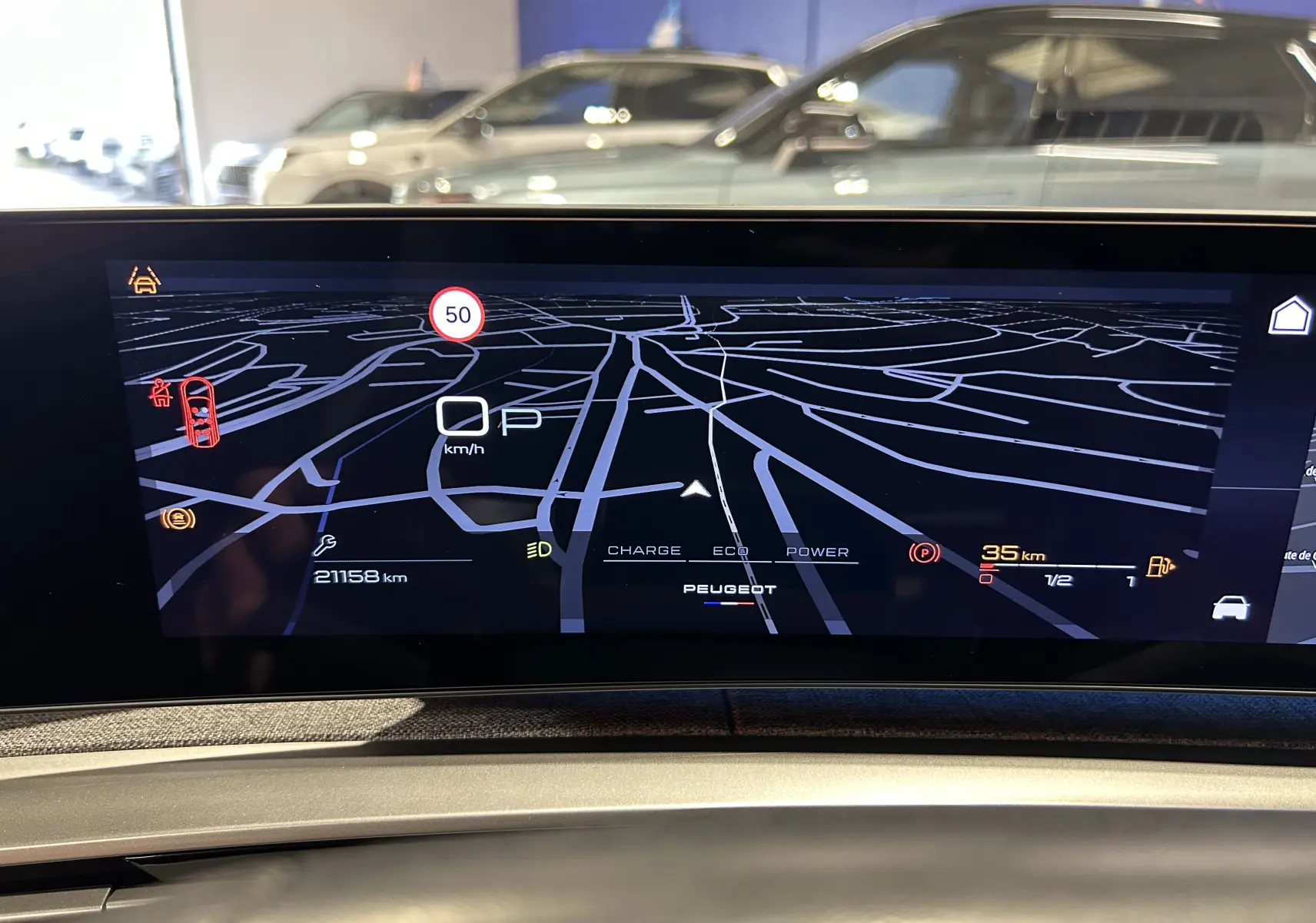 Écran numérique de tableau de bord du Peugeot 5008 III Hybrid 145, affichant la navigation et les informations de conduite.