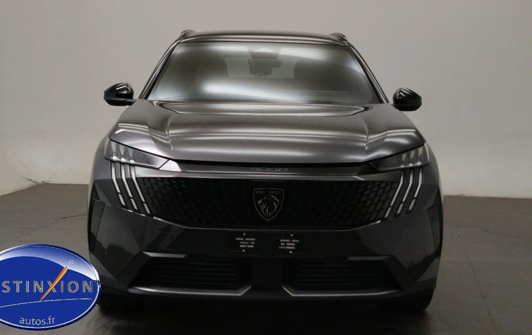 Vue avant rapprochée du Peugeot 5008 gris titane avec feux LED distinctifs et calandre noire brillante.