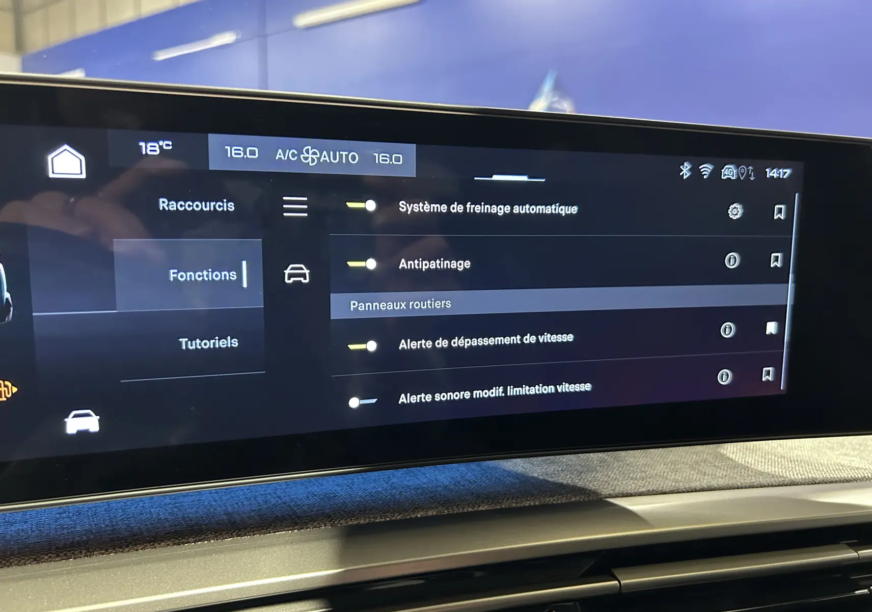 Écran tactile du tableau de bord du Peugeot 5008 Hybrid affichant les réglages d’aides à la conduite et climatisation à 16°C.
