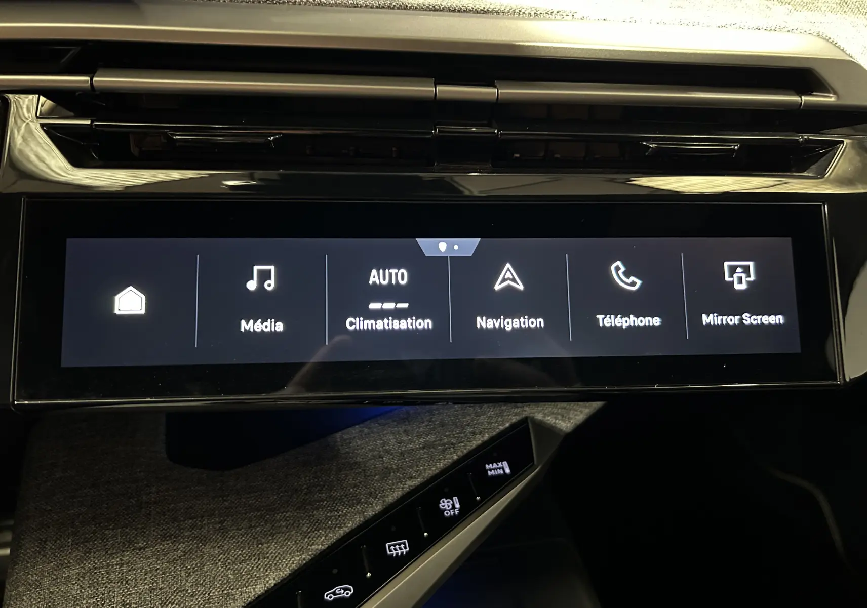 Écran tactile central du tableau de bord du Peugeot 5008 III Hybrid 145 en intérieur, affichant les menus multimédia et navigation.