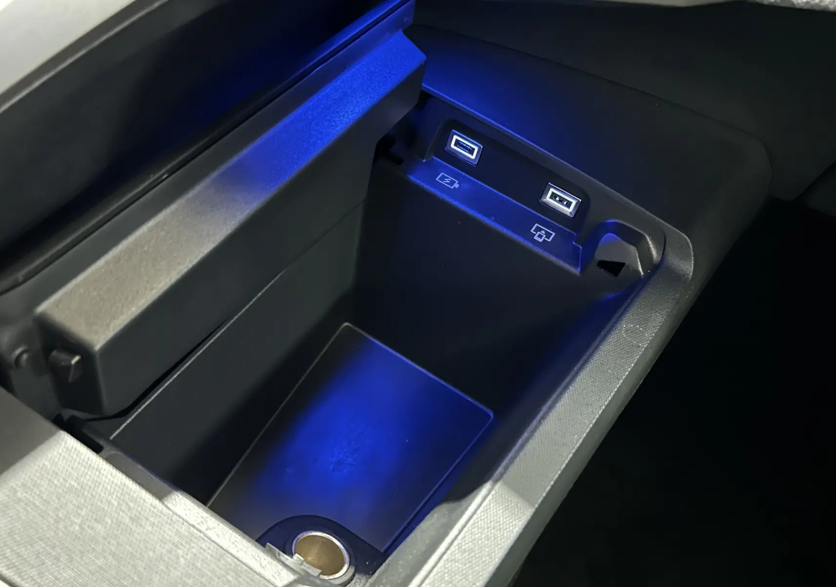 Gros plan sur la console centrale intérieure du Peugeot 5008 III Hybrid, montrant deux ports USB avec éclairage bleu.
