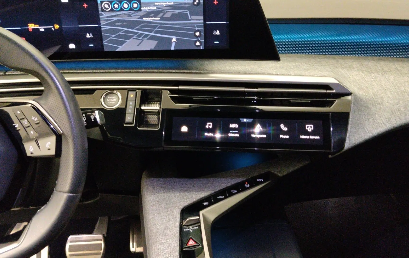 Vue intérieure côté conducteur du Peugeot 5008 III Hybrid 145 e-DCS6 GT, avec tableau de bord numérique et sellerie noire.
