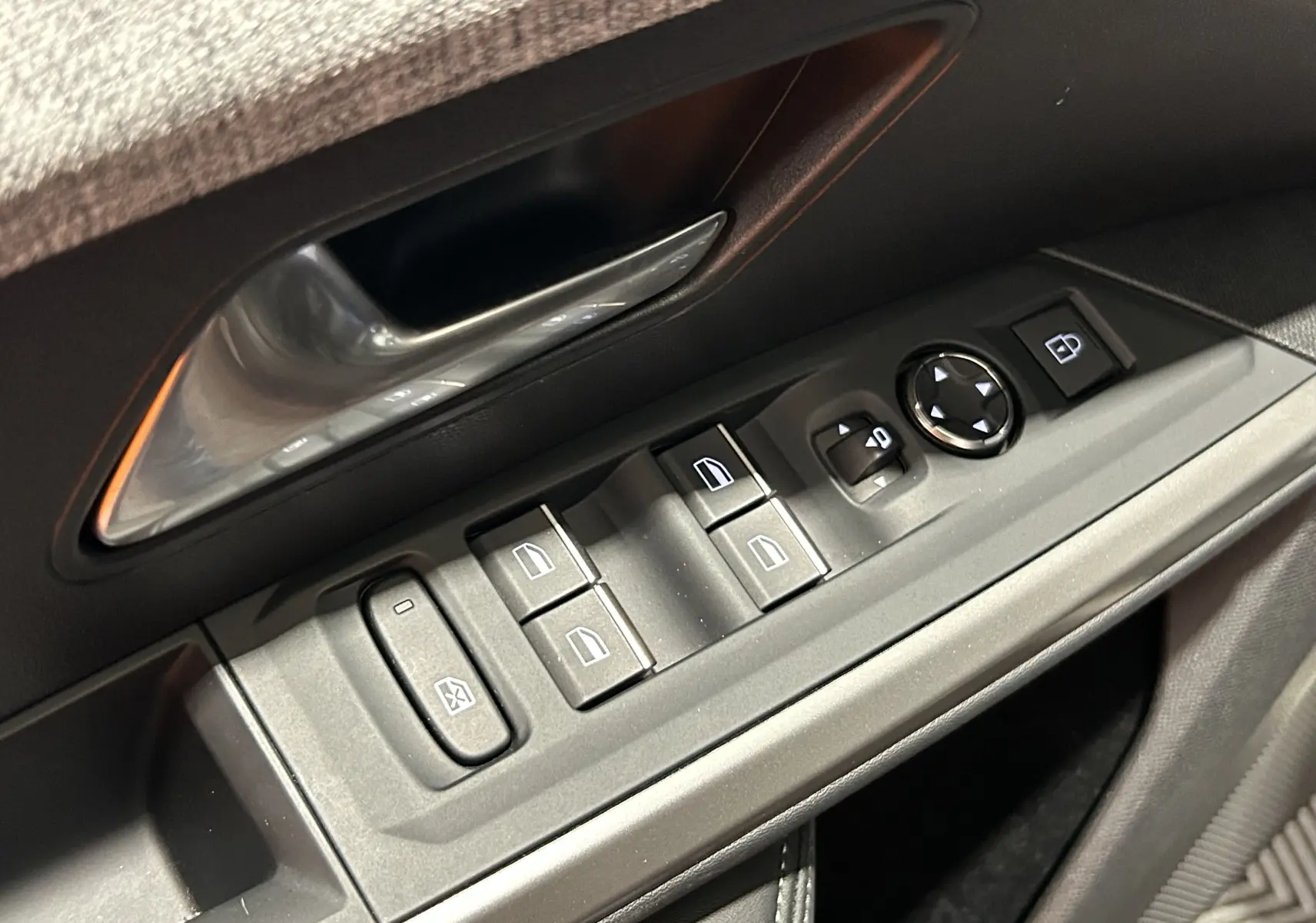 Gros plan sur les commandes de lève-vitres et rétroviseurs côté conducteur du Peugeot 5008 gris Titane 2025.