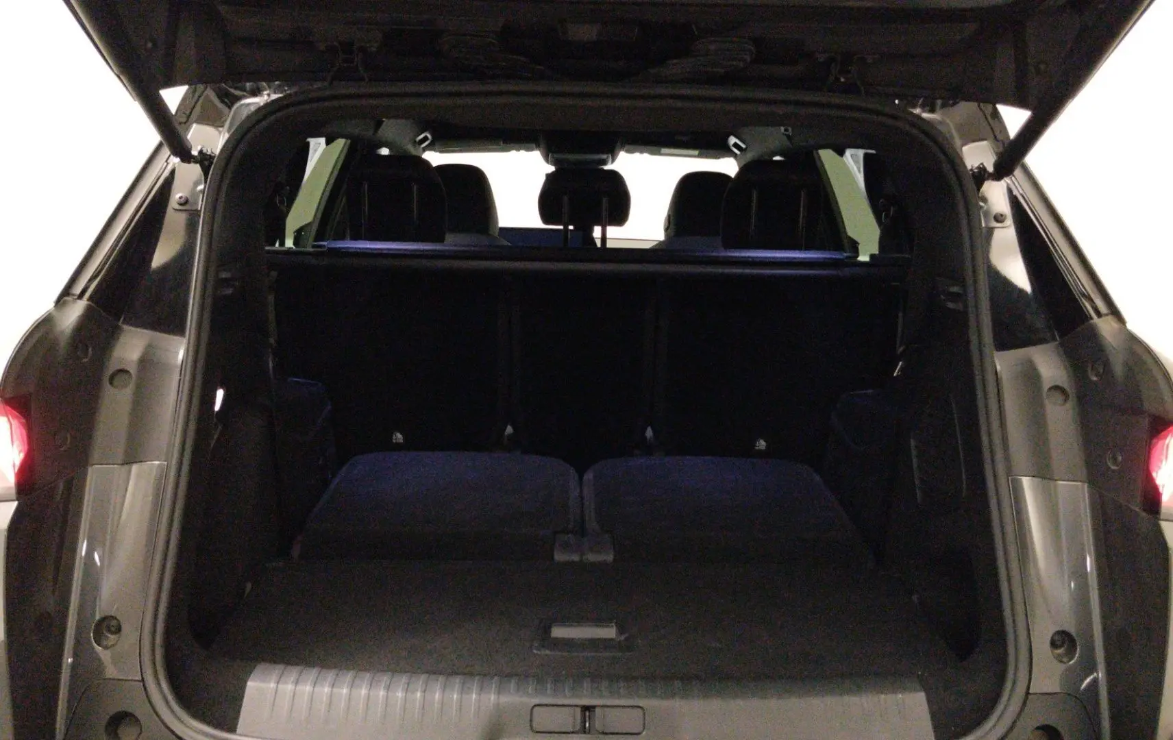 Vue intérieure côté droit des sièges arrière en cuir noir avec surpiqûres blanches du Peugeot 5008 III Hybrid 145 GT gris titane.