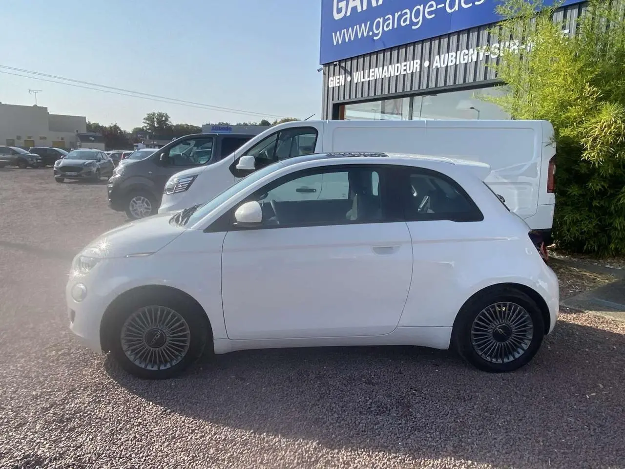 Profil latéral droit d'une Fiat 500 électrique blanche 2022 avec toit panoramique et jantes spécifiques Icône.