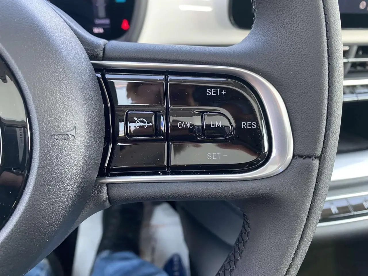 Gros plan sur les commandes de régulateur de vitesse au volant d'une Fiat 500 électrique blanche de 2022.