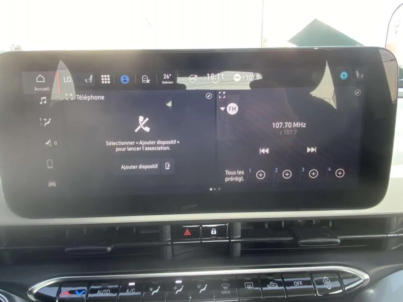 Écran tactile central du système Uconnect 10,25" de la Fiat 500 Électrique blanche, affichant radio FM et options téléphone.