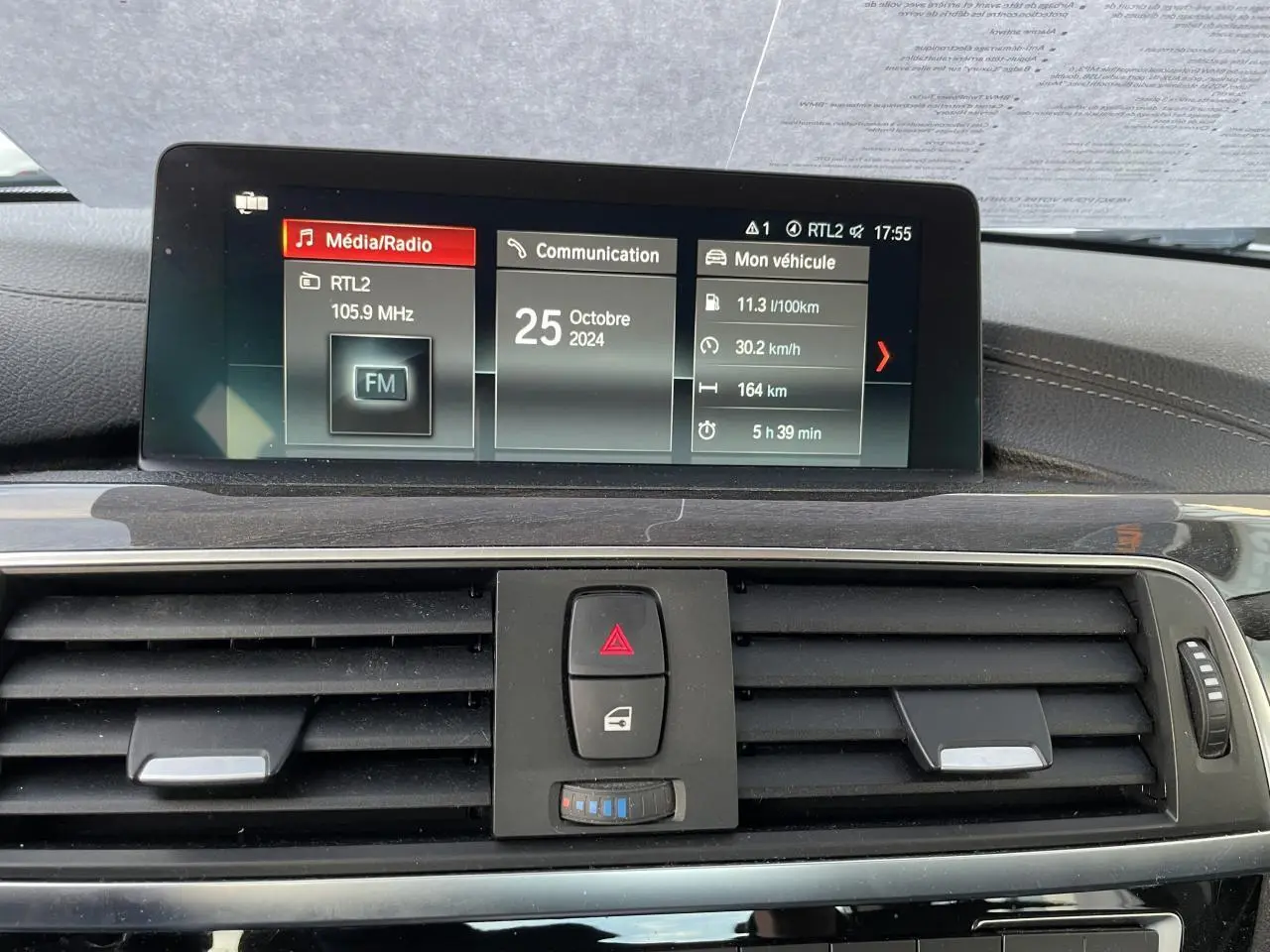 Écran multimédia et commandes centrales du tableau de bord en bois foncé d'une BMW Série 3 F30 gris clair de 2018.