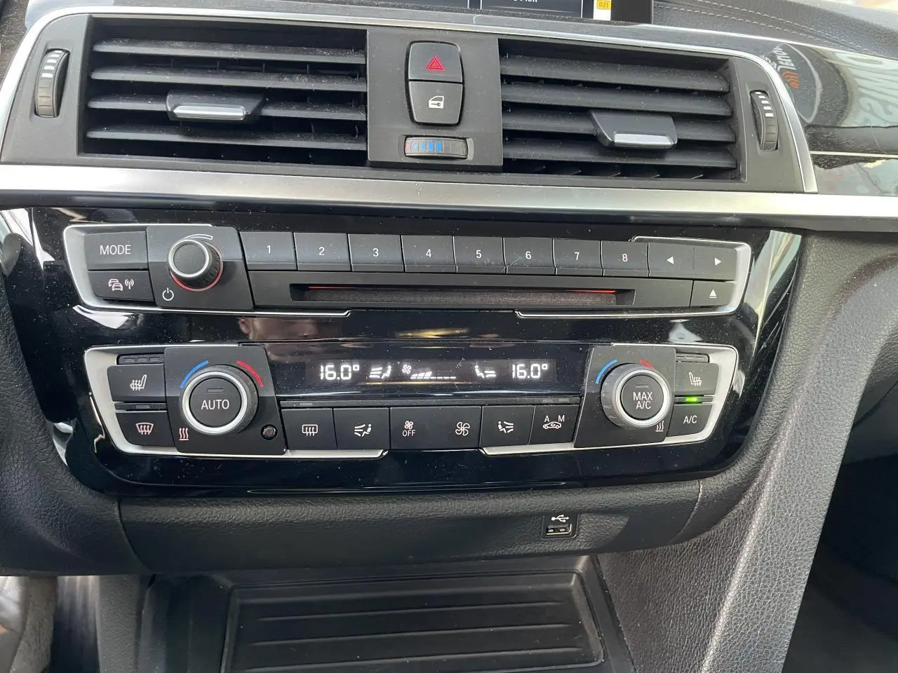 Console centrale noire brillante de la BMW Série 3 F30 330i xDrive 2018 avec commandes climatisation automatique et radio.