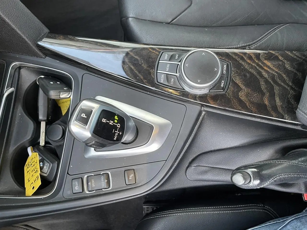 Vue rapprochée de la console centrale en bois précieux et cuir noir avec levier de vitesse automatique d'une BMW Série 3 F30.