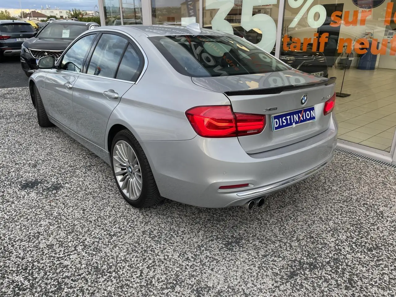 BMW Série 3 F30 330i xDrive gris clair vue 3/4 arrière droit avec jantes alliage et double sortie d’échappement