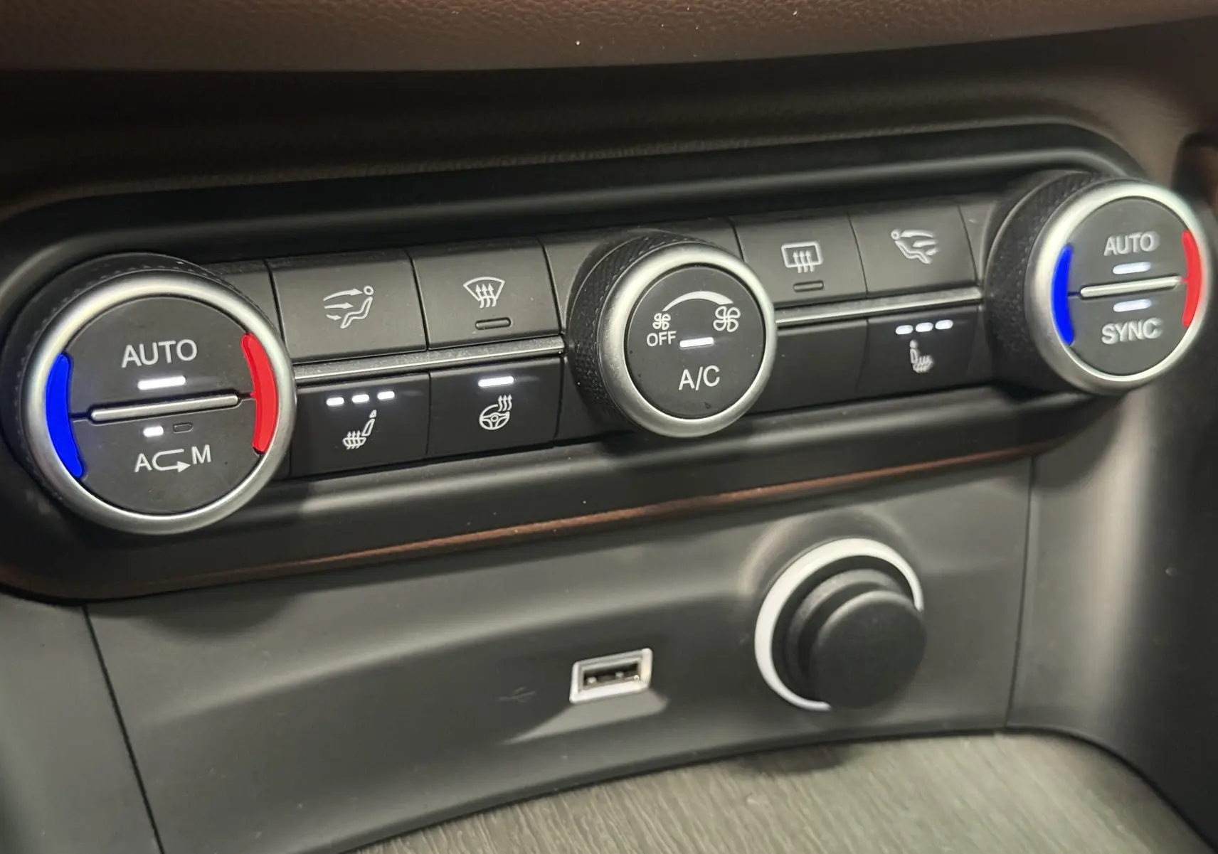 Détail du tableau de bord de l'Alfa Romeo Stelvio gris 2017 montrant les commandes de climatisation automatique et USB.
