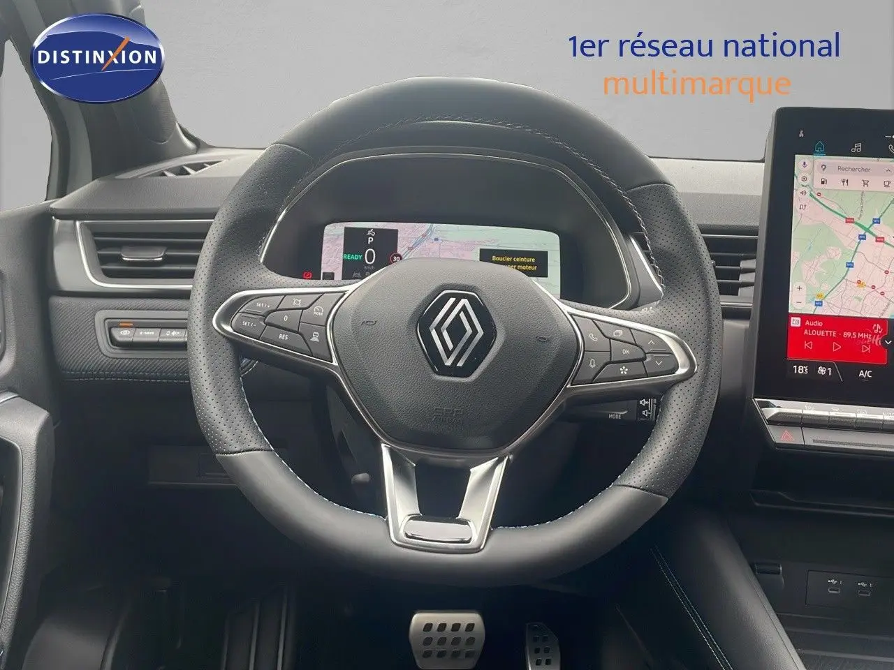Vue rapprochée du volant noir perforé et du tableau de bord numérique du Renault Captur E-Tech hybride 2025.