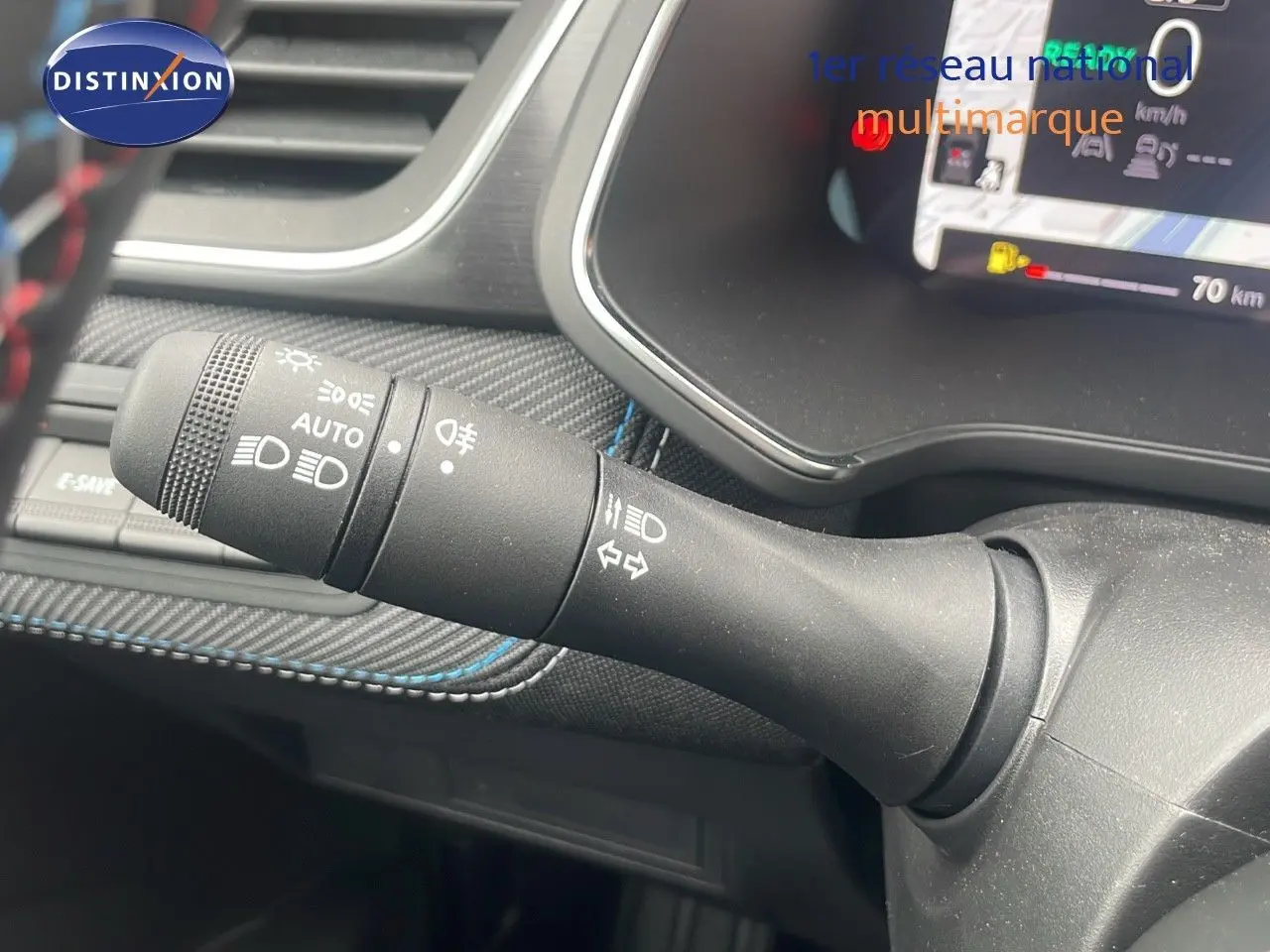 Gros plan sur la commande des feux et clignotants du tableau de bord du Renault Captur blanc nacré 2025.