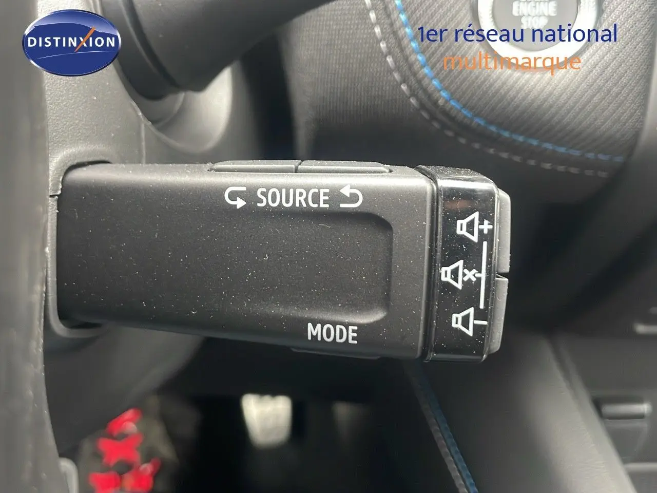 Commande au volant avec boutons source et mode, volant noir avec surpiqûres bleues dans Renault Captur E-Tech hybride 2025