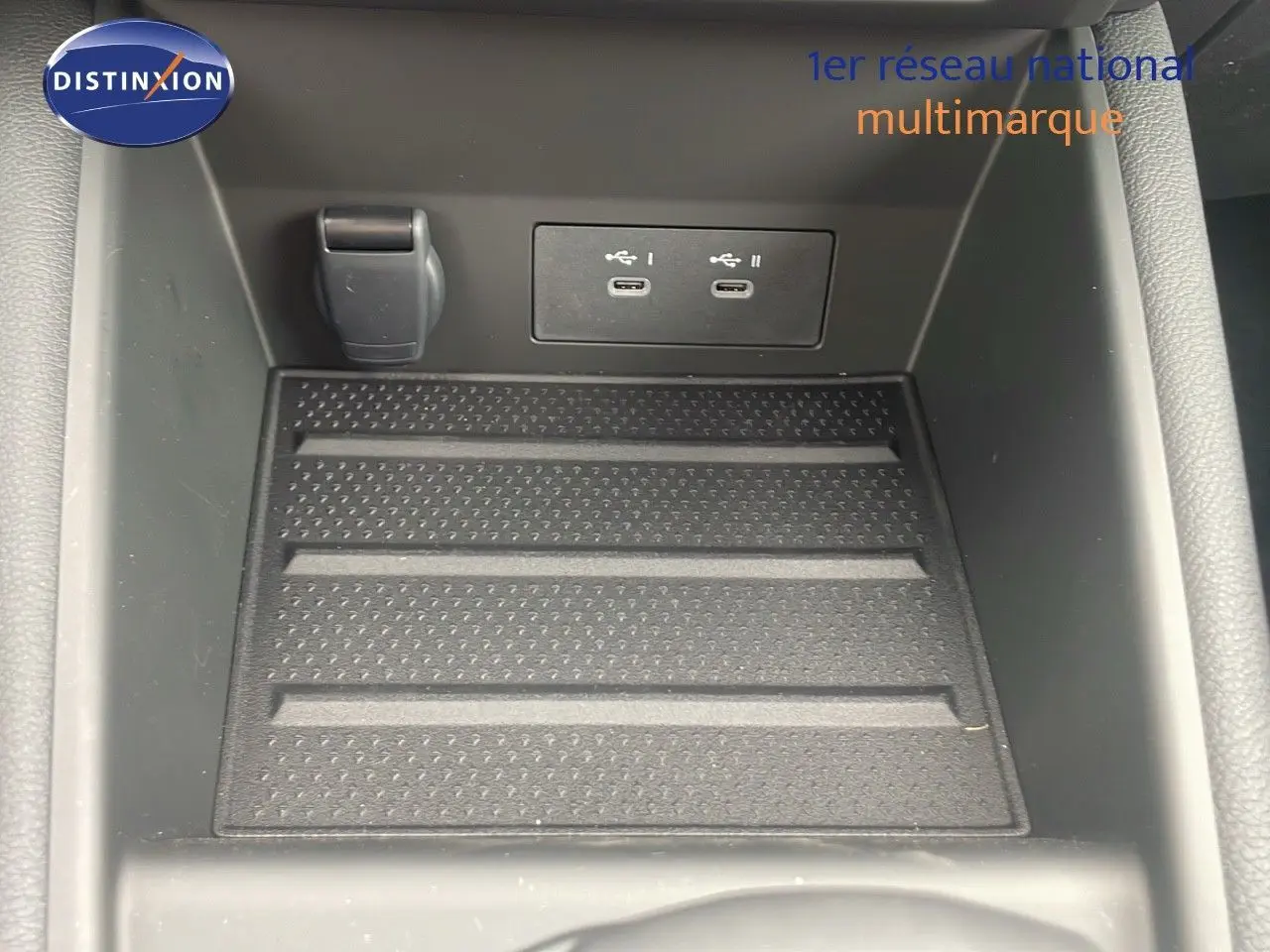 Gros plan sur la console centrale du Renault Captur E-Tech hybride 2025 avec ports USB-C et prise 12V.