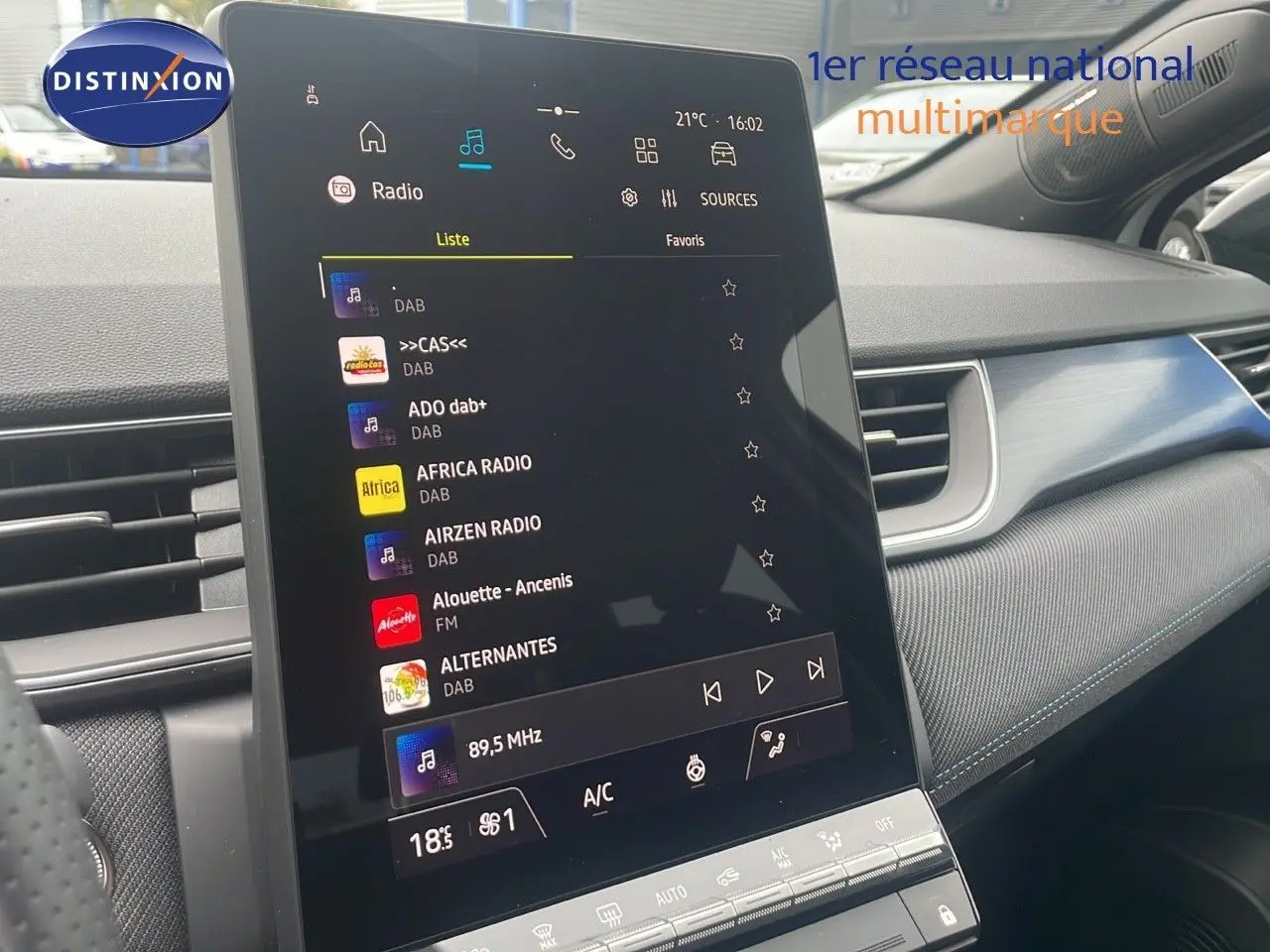 Écran tactile central du Renault Captur E-Tech blanc nacré, affichant les options radio et climatisation dans l'habitacle.