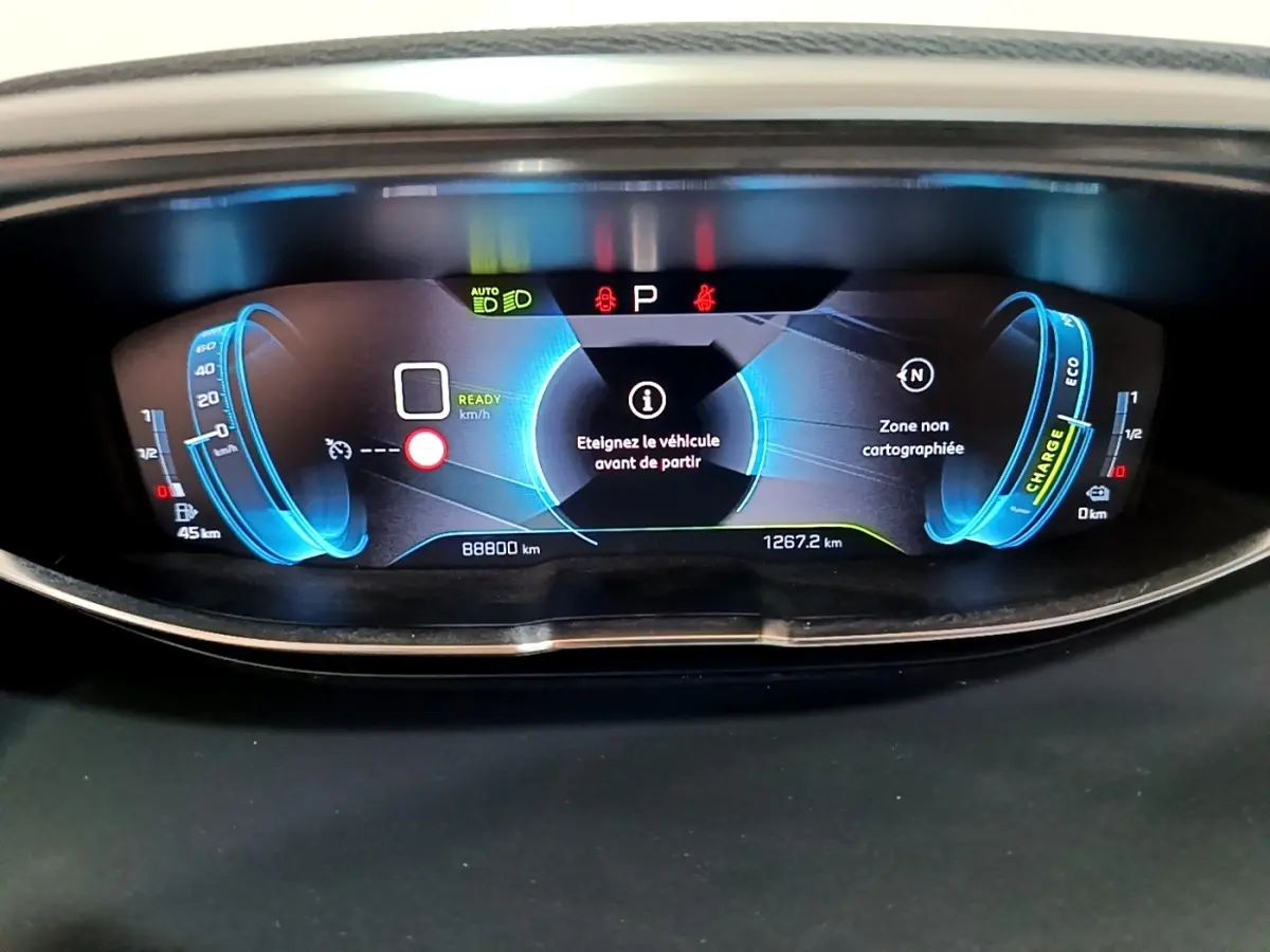 Tableau de bord numérique du Peugeot 3008 hybride 2020, affichage bleu avec alertes et compteurs détaillés.