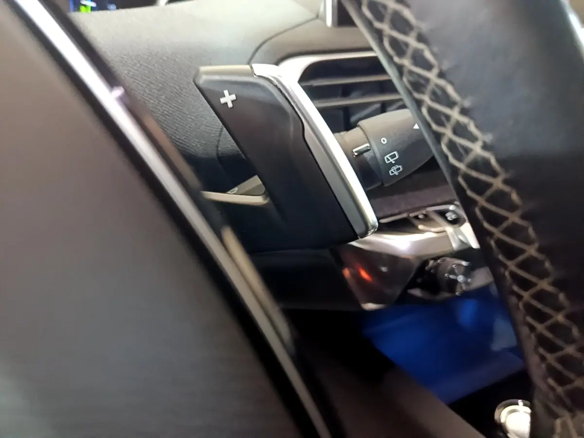 Gros plan sur la palette de changement de vitesse côté droit du volant cuir du Peugeot 3008 blanc hybride rechargeable.
