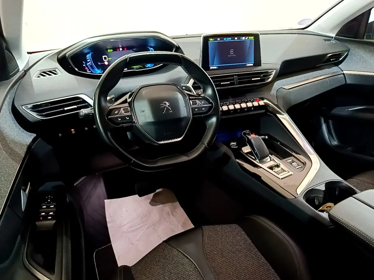 Vue intérieure avant du Peugeot 3008 blanc hybride rechargeable, avec tableau de bord numérique et écran tactile central.