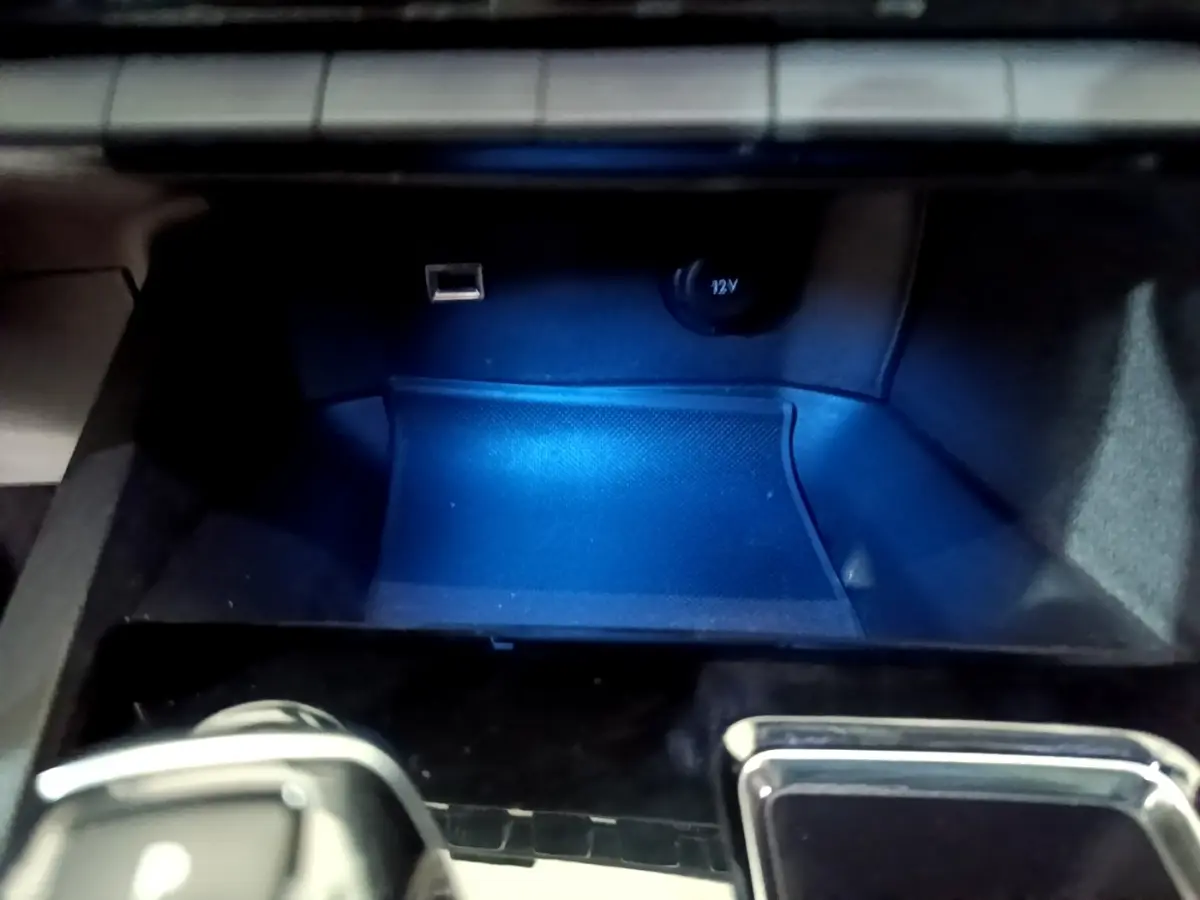 Gros plan sur la prise USB et prise 12V dans le rangement avant du Peugeot 3008 blanc hybride rechargeable.