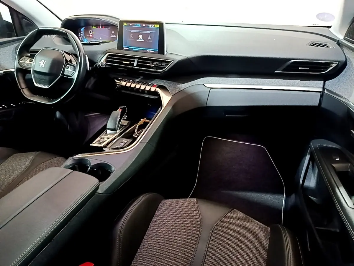 Vue intérieure avant droite du Peugeot 3008 blanc, mettant en valeur le tableau de bord digital et la console centrale moderne.