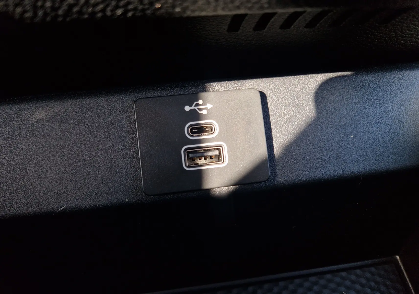 Gros plan sur les ports USB Type-C et USB-A intégrés dans l'habitacle noir du Ford Ranger Super Cabine gris Iconic 2026.