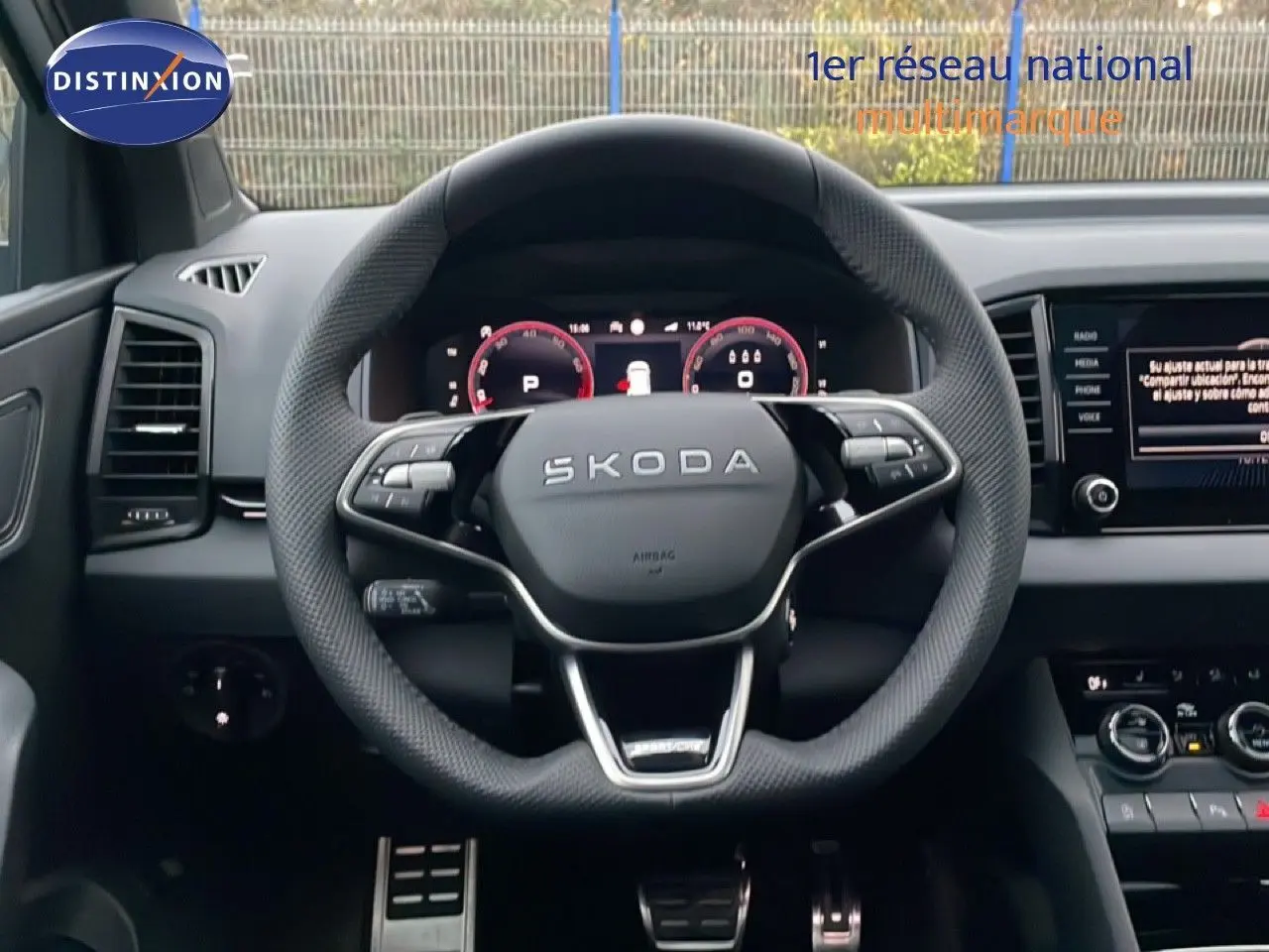 Vue centrée sur le volant SKODA KAROQ 2025 gris argent, tableau de bord digital et écran multimédia visible.