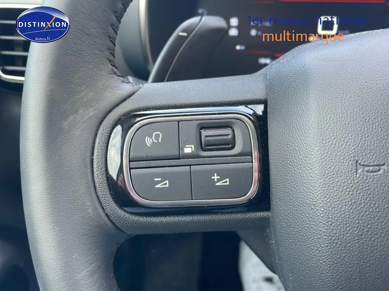 Gros plan sur les commandes gauche du volant cuir noir du Citroën C5 Aircross hybride 2025.