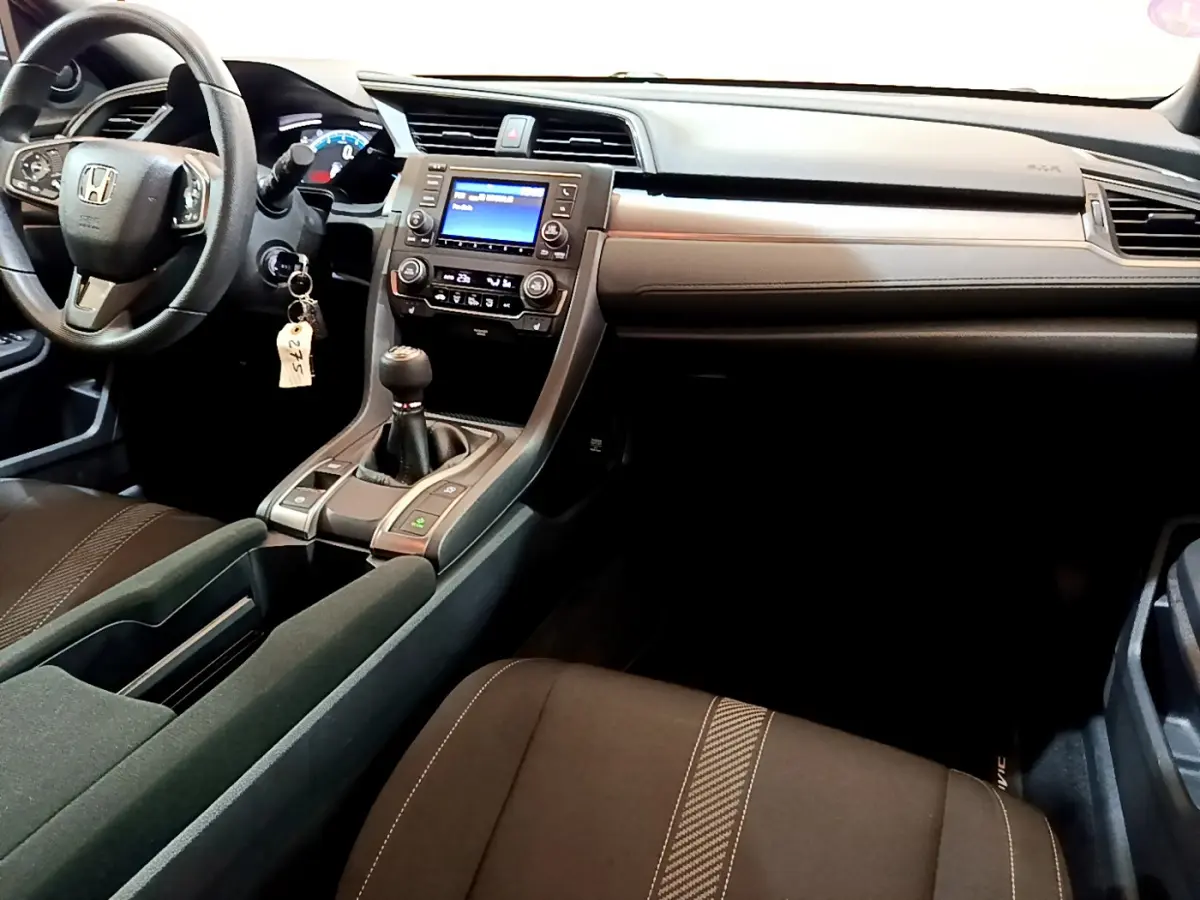 Vue intérieure avant droite de la Honda Civic 1.0 i-VTEC 2020, tableau de bord noir avec écran tactile et boîte manuelle.