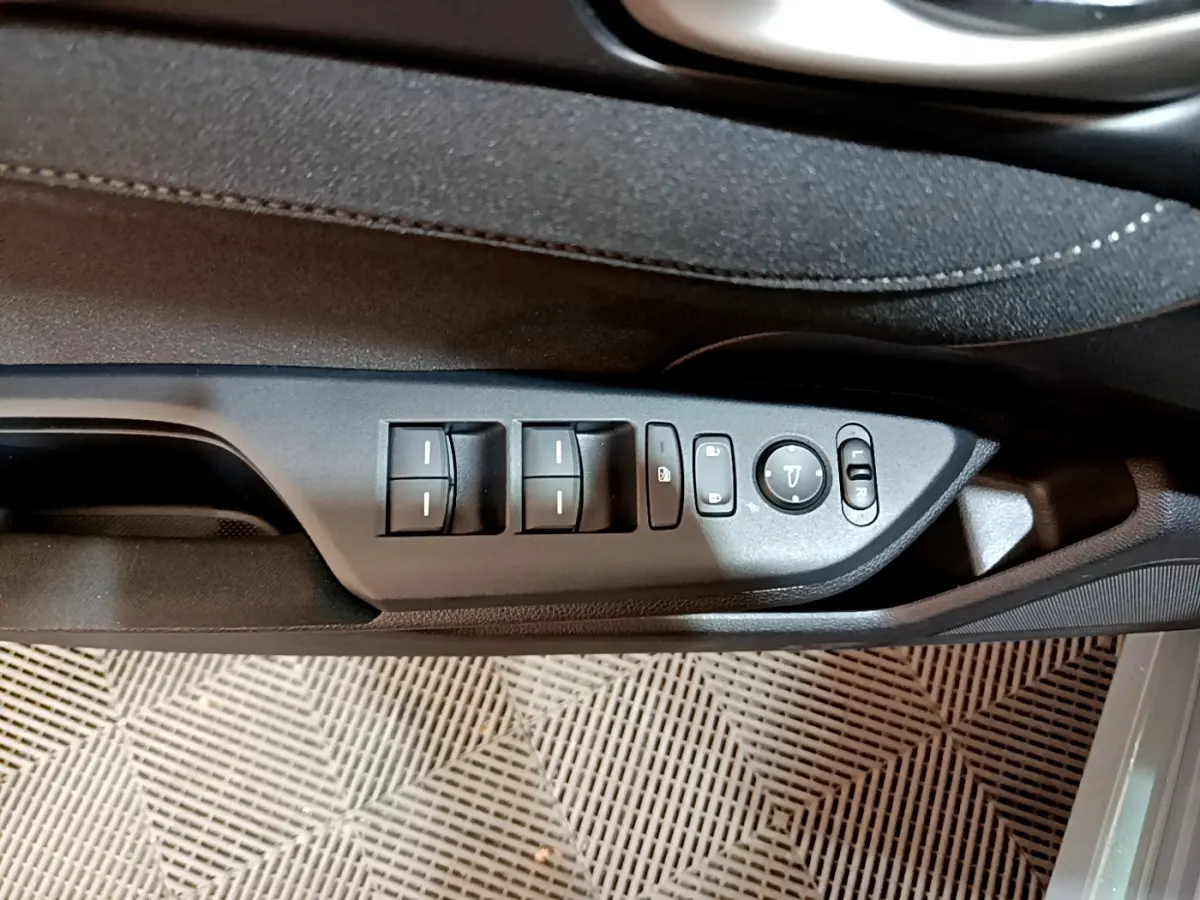 Gros plan sur les commandes de lève-vitres et rétroviseurs côté conducteur de la Honda Civic gris foncé 2020.