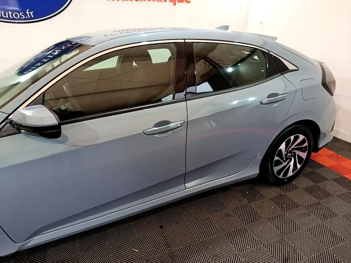 Vue latérale droite d'une Honda Civic gris foncé 2020, mettant en valeur les lignes épurées et les jantes stylisées.
