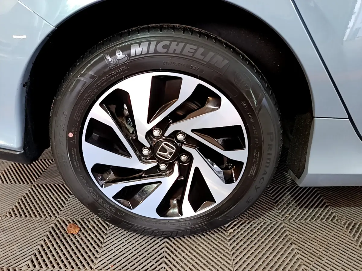 Gros plan sur la roue avant droite d'une Honda Civic 1.0 i-VTEC Exclusive gris foncé avec jante alliage et pneu Michelin.