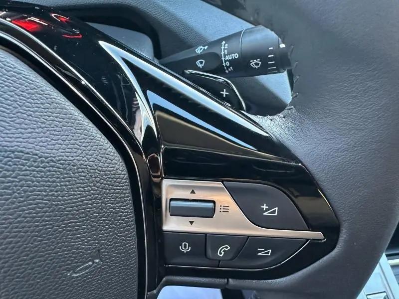 Détail du volant côté gauche du Peugeot 308 SW 2024, avec commandes audio et téléphone intégrées.