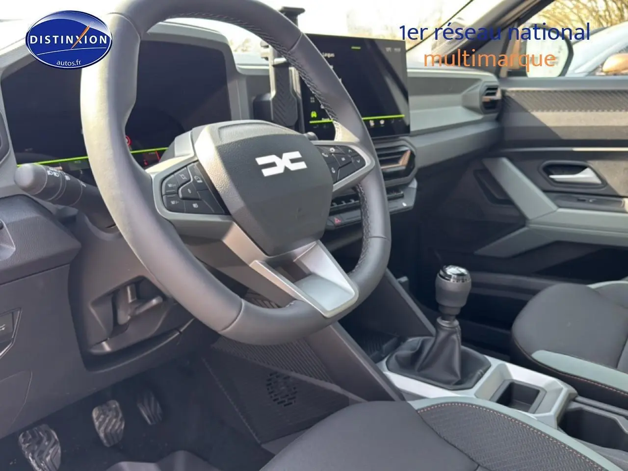 Vue intérieure avant du Dacia Bigster gris schiste, montrant le volant multifonction, la boîte manuelle et l’écran tactile central.
