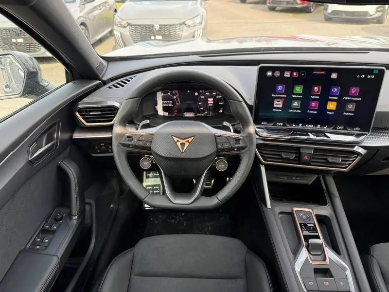 Vue intérieure centrée sur le volant et tableau de bord du CUPRA Formentor gris Graphène avec écran tactile et commandes modernes.