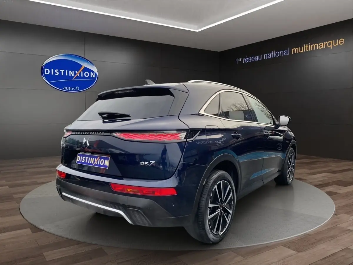DS7 Crossback bleu vue 3/4 arrière droit, feux arrière LED fins et jantes alliage noires et argentées.