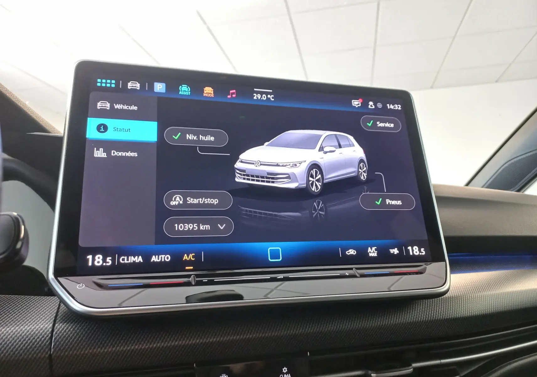 Écran tactile central affichant l'état du véhicule Volkswagen Golf 2025 avec interface moderne et commandes climatisation.