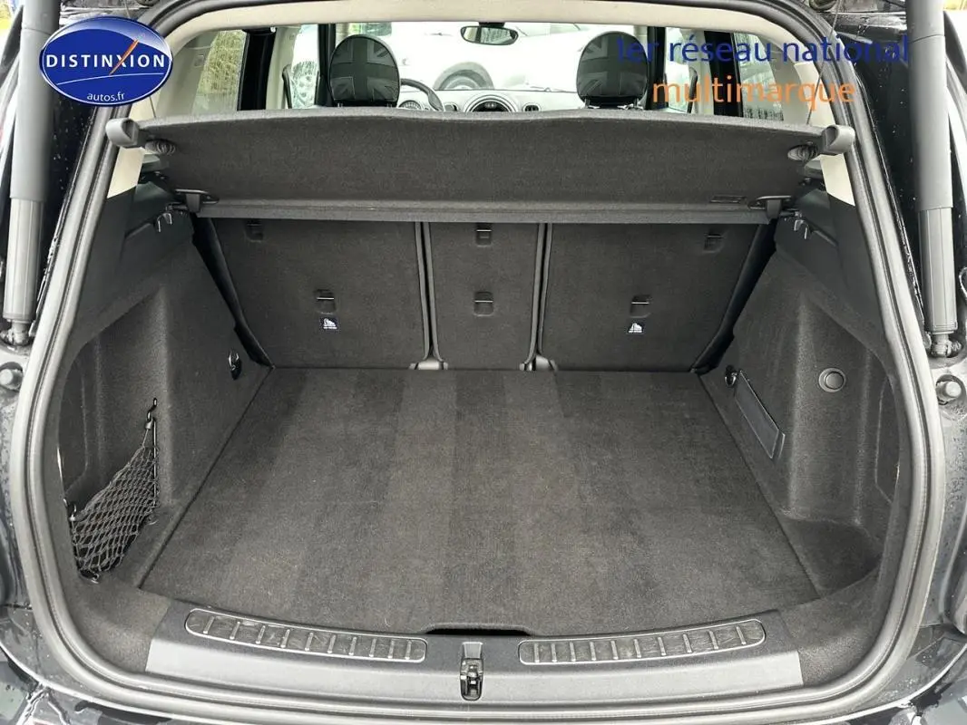 Coffre ouvert en vue arrière d’un MINI Countryman noir, montrant un espace de chargement propre et bien agencé.