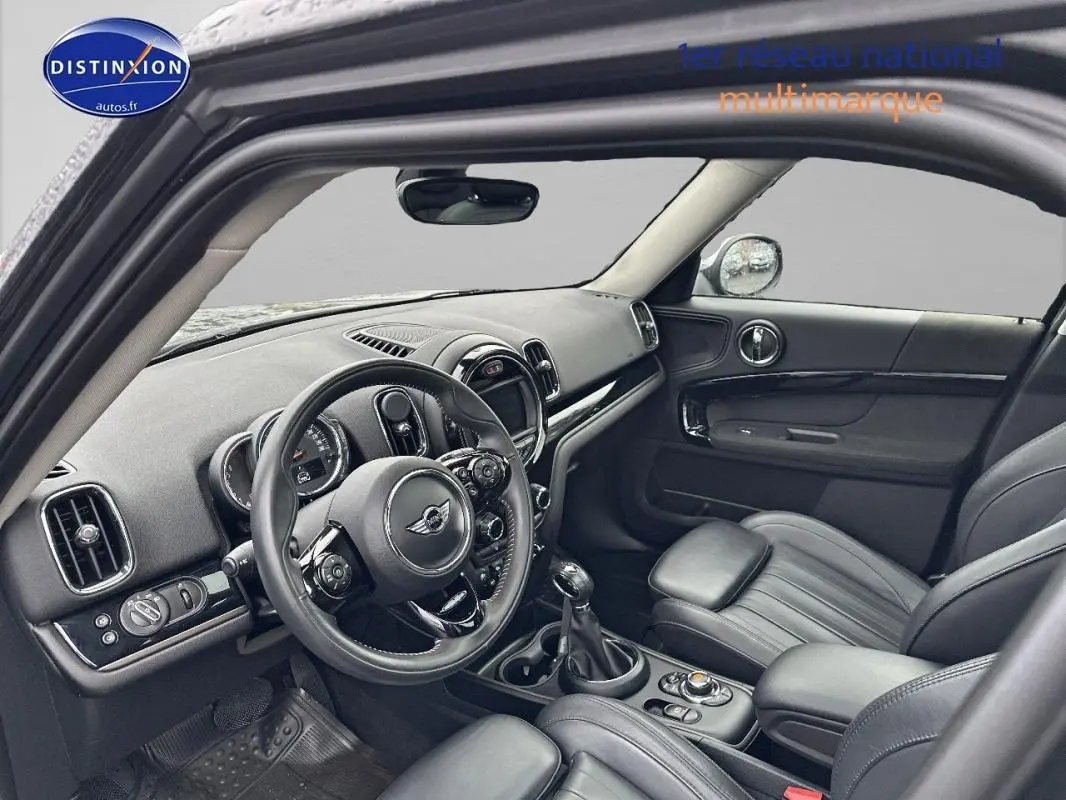 Vue intérieure côté conducteur de la MINI Countryman noire, mettant en valeur le volant sport et la console centrale.